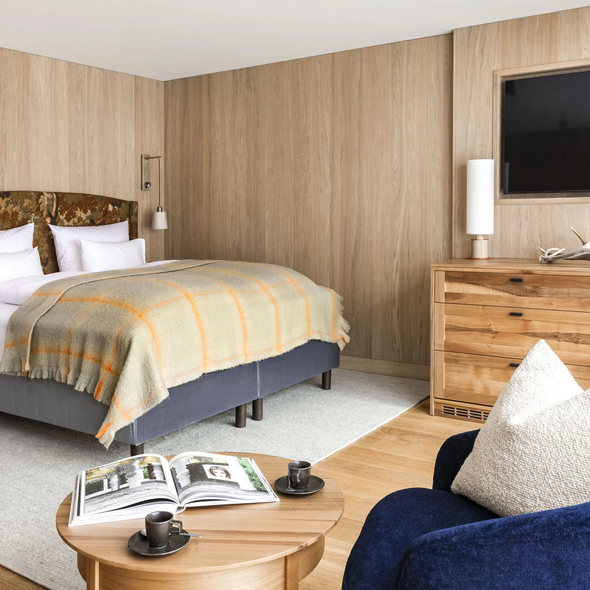 Ihr Hotel in Lech am Arlberg. Das Sunora. Gemütliches Schlafzimmer mit Holzverkleidung, Doppelbett und TV