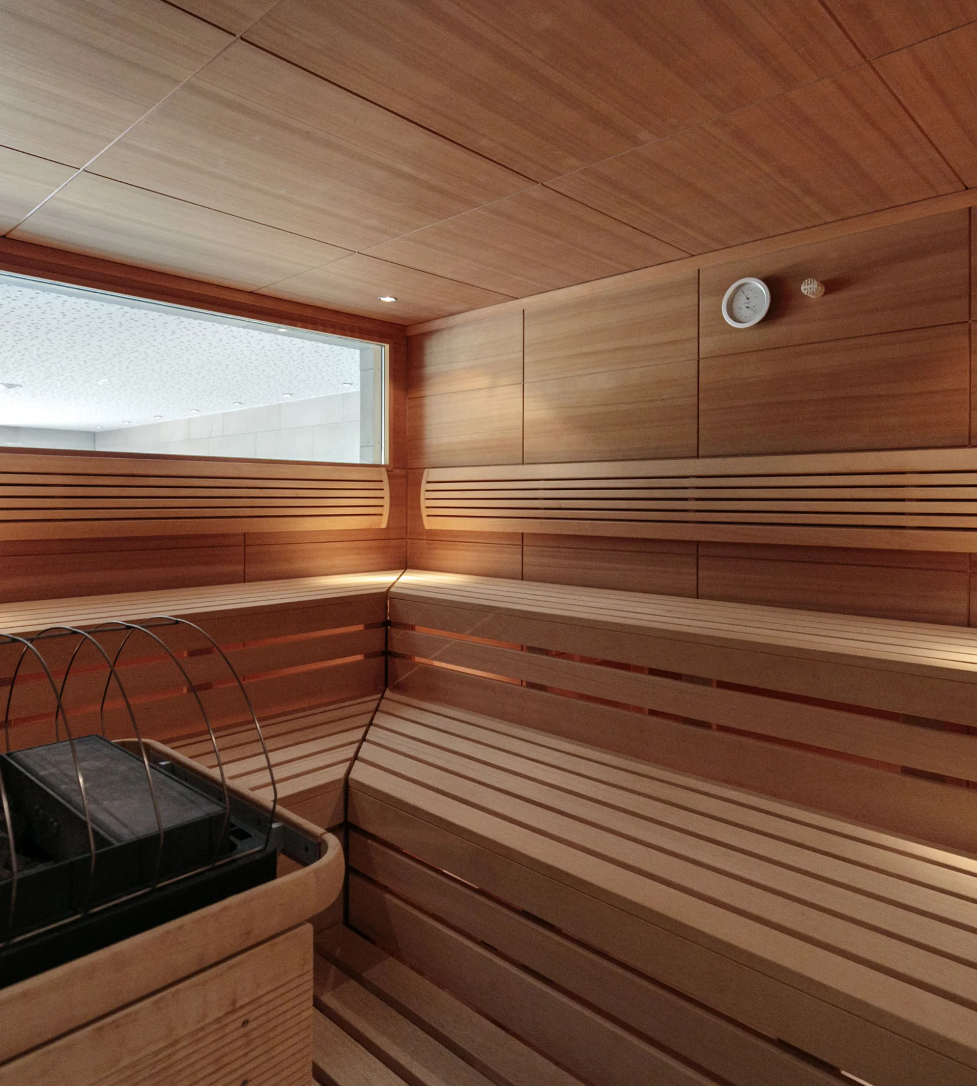 Ihr Hotel in Lech am Arlberg. Das Sunora. Innenansicht einer Holzsauna mit Ofen und Sitzbänken