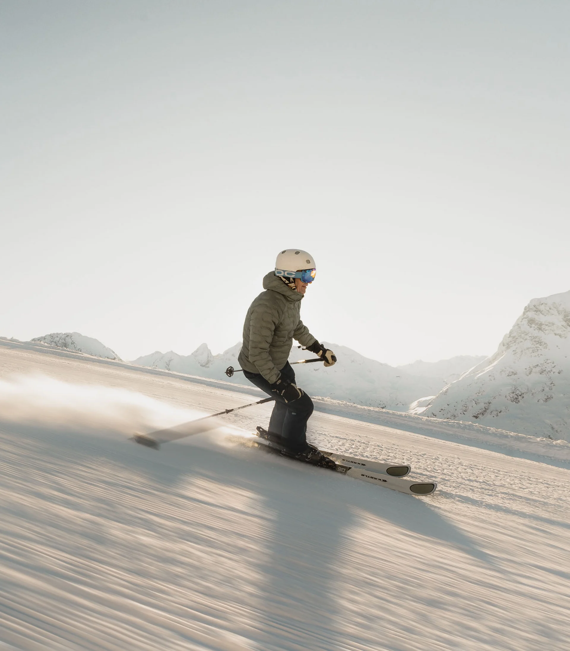 Ihr Hotel in Lech am Arlberg. Das Sunora. Skifahrer fährt bei klarem Himmel auf präparierter Piste in den Bergen