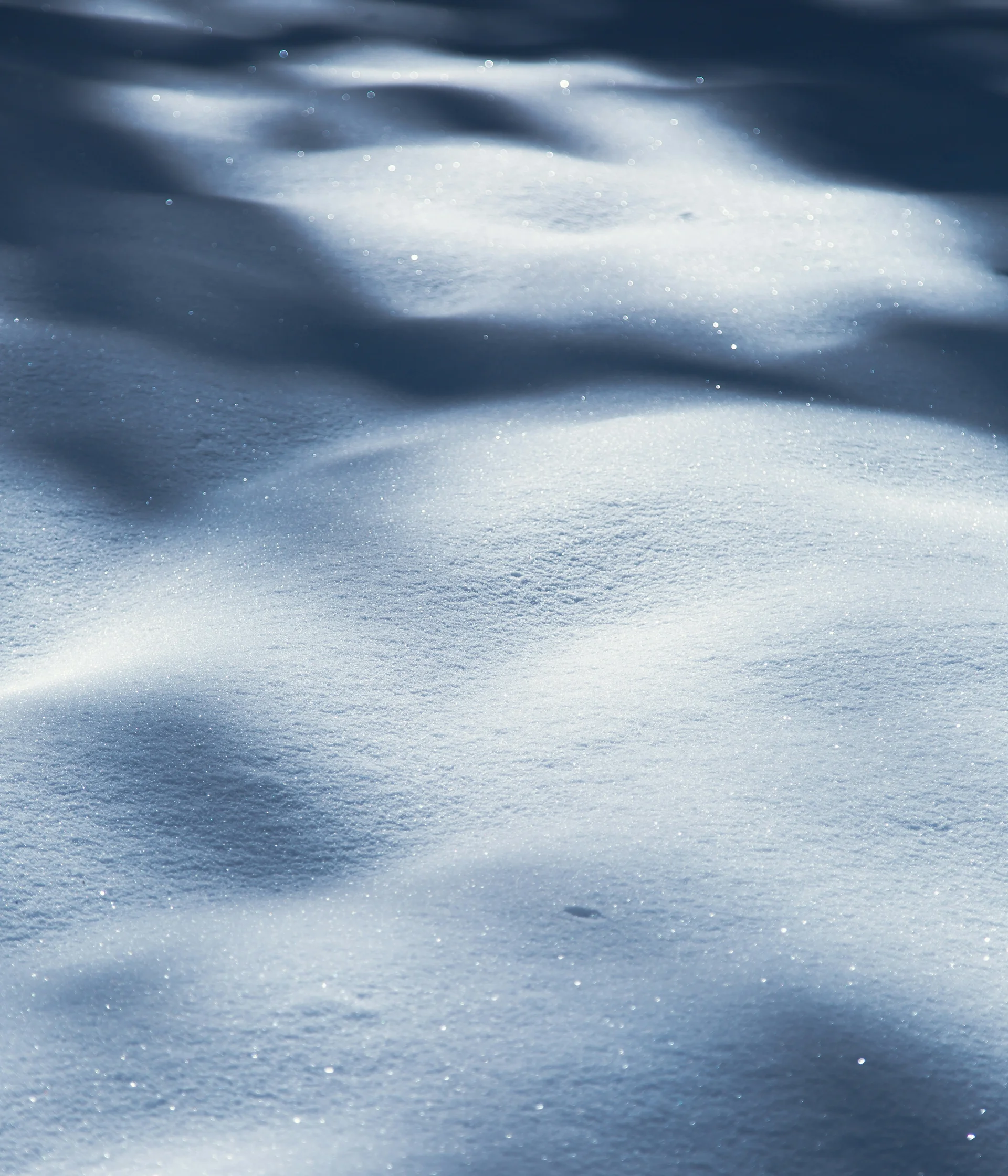 Ihr Hotel in Lech am Arlberg. Das Sunora. Nahaufnahme von schimmerndem Schnee mit Licht- und Schatteneffekten